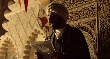 Movie still from “Reds” (1981), directed by Warren Beatty – A man in a turban is reading a newspaper; Medium shot, Low angle