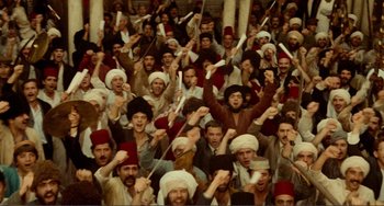 Movie still from “Reds” (1981), directed by Warren Beatty – A large group of people in a crowd with hats on; Extreme Wide shot, High angle