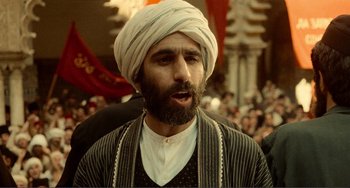 Movie still from “Reds” (1981), directed by Warren Beatty – A man with a beard wearing a turban; Close Up shot, Over the shoulder angle