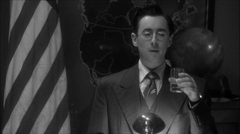 Movie still from “Reefer Madness: The Movie Musical” (2005), directed by Andy Fickman – A black and white photo of a man holding a glass of wine; Close Up shot, Low angle