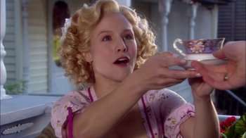 Movie still from “Reefer Madness: The Movie Musical” (2005), directed by Andy Fickman – A woman with blonde curly hair is holding a cup; Close Up shot, Over the shoulder angle