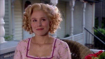 Movie still from “Reefer Madness: The Movie Musical” (2005), directed by Andy Fickman – A woman with blonde curly hair sitting on a chair; Close Up shot, Over the shoulder angle