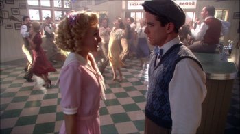 Movie still from “Reefer Madness: The Movie Musical” (2005), directed by Andy Fickman – A man and a woman standing next to each other in front of a dance floor; Medium shot, High angle
