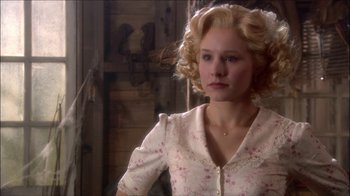 Movie still from “Reefer Madness: The Movie Musical” (2005), directed by Andy Fickman – A woman with blonde curly hair wearing a white dress; Close Up shot, Over the shoulder angle