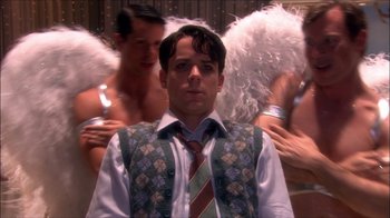 Movie still from “Reefer Madness: The Movie Musical” (2005), directed by Andy Fickman – A man in a vest and tie standing in front of two other men; Medium shot, Over the shoulder angle