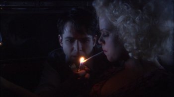 Movie still from “Reefer Madness: The Movie Musical” (2005), directed by Andy Fickman – A man and a woman are lighting a candle; Close Up shot, High angle