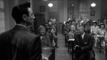 Movie still from “Reefer Madness: The Movie Musical” (2005), directed by Andy Fickman – An old photo of people sitting in a room; Wide shot, Over the shoulder angle