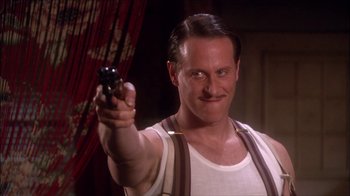 Movie still from “Reefer Madness: The Movie Musical” (2005), directed by Andy Fickman – A man holding a gun pointed at the camera; Close Up shot, Low angle