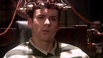 Movie still from “Reefer Madness: The Movie Musical” (2005), directed by Andy Fickman – A man with a hair dryer on top of his head; Close Up shot, High angle