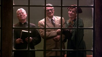 Movie still from “Reefer Madness: The Movie Musical” (2005), directed by Andy Fickman – A group of people standing in front of a jail cell; Medium shot, Low angle
