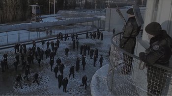 Movie still from “Reindeer Games” (2000), directed by John Frankenheimer – A group of people walking in the snow near a fence; Extreme Wide shot, High angle