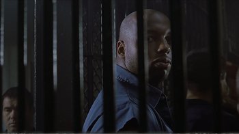 Movie still from “Reindeer Games” (2000), directed by John Frankenheimer – A man standing behind bars in a jail cell; Close Up shot, Low angle