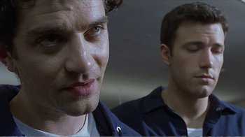Movie still from “Reindeer Games” (2000), directed by John Frankenheimer – Two men standing next to each other in front of a wall; Close Up shot, Low angle