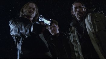 Movie still from “Reindeer Games” (2000), directed by John Frankenheimer – A group of men standing next to each other holding guns; Medium shot, Low angle