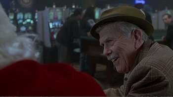 Movie still from “Reindeer Games” (2000), directed by John Frankenheimer – An older man wearing a hat and smiling; Close Up shot, Over the shoulder angle