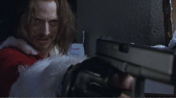 Movie still from “Reindeer Games” (2000), directed by John Frankenheimer – A man with long hair is holding a gun in his hand; Close Up shot, Low angle