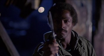 Movie still from “Remo Williams: The Adventure Begins” (1985), directed by Guy Hamilton – A man holding a pair of scissors in his hand; Close Up shot, Low angle