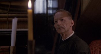 Movie still from “Remo Williams: The Adventure Begins” (1985), directed by Guy Hamilton – An older man is looking at the camera; Close Up shot, Over the shoulder angle