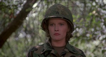 Movie still from “Remo Williams: The Adventure Begins” (1985), directed by Guy Hamilton – A woman wearing a camouflage uniform and a helmet; Close Up shot, Low angle