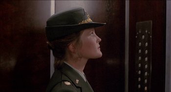 Movie still from “Remo Williams: The Adventure Begins” (1985), directed by Guy Hamilton – A woman in a military uniform looking to the side; Close Up shot, Low angle