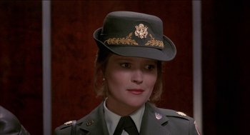 Movie still from “Remo Williams: The Adventure Begins” (1985), directed by Guy Hamilton – A woman wearing a uniform and a hat; Close Up shot, Over the shoulder angle