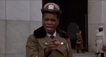 Movie still from “Remo Williams: The Adventure Begins” (1985), directed by Guy Hamilton – A woman wearing a uniform and a hat; Close Up shot, Low angle