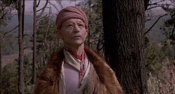 Movie still from “Remo Williams: The Adventure Begins” (1985), directed by Guy Hamilton – An old man wearing a fur coat and a pink turban; Close Up shot, Low angle