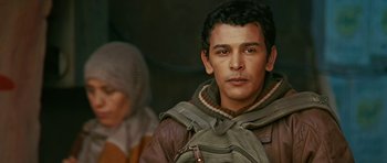 Movie still from “Rendition” (2007), directed by Gavin Hood – A man with a backpack is standing next to a woman; Close Up shot, Over the shoulder angle