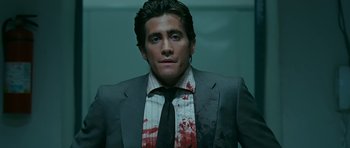 Movie still from “Rendition” (2007), directed by Gavin Hood – A person wearing a suit with blood on it; Medium shot, Low angle