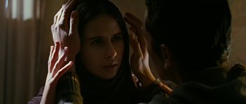 Movie still from “Rendition” (2007), directed by Gavin Hood – A woman in a head scarf looking at a man in a dark room; Close Up shot, Over the shoulder angle