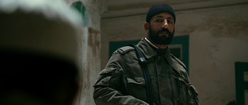 Movie still from “Rendition” (2007), directed by Gavin Hood – A man with a beard wearing a black hat; Close Up shot, Over the shoulder angle