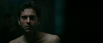 Movie still from “Rendition” (2007), directed by Gavin Hood – A man with no shirt is looking at the camera; Close Up shot, High angle