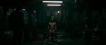 Movie still from “Rendition” (2007), directed by Gavin Hood – A naked man sitting in a chair; Wide shot, High angle