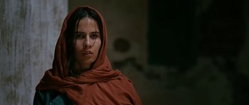 Movie still from “Rendition” (2007), directed by Gavin Hood – A woman with a red head covering is looking at the camera; Close Up shot, Low angle