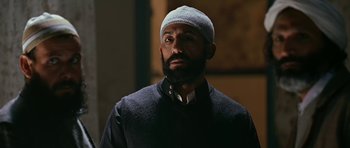 Movie still from “Rendition” (2007), directed by Gavin Hood – A man with a beard wearing a white hat; Close Up shot, Low angle