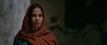 Movie still from “Rendition” (2007), directed by Gavin Hood – A woman with a red head covering is looking at the camera; Close Up shot, Low angle