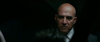 Movie still from “Rendition” (2007), directed by Gavin Hood – A man with bald head wearing a white shirt and tie; Close Up shot, Over the shoulder angle