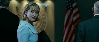 Movie still from “Rendition” (2007), directed by Gavin Hood – A woman standing in front of an american flag; Close Up shot, Over the shoulder angle