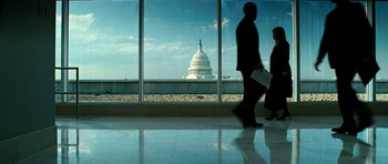 Movie still from “Rendition” (2007), directed by Gavin Hood – Two people are walking in front of a large window; Extreme Wide shot, Low angle