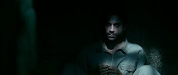 Movie still from “Rendition” (2007), directed by Gavin Hood – A man in a dark room holding something in his hand; Close Up shot, Overhead angle