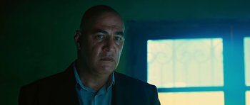 Movie still from “Rendition” (2007), directed by Gavin Hood – A man in a suit and tie looking into the distance; Close Up shot, Low angle