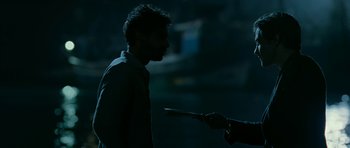 Movie still from “Rendition” (2007), directed by Gavin Hood – A man holding a knife in his hand and looking at another man; Medium shot, Over the shoulder angle