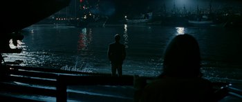 Movie still from “Rendition” (2007), directed by Gavin Hood – A man standing in front of a body of water at night; Extreme Wide shot, High angle
