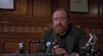 Movie still from “Return to Oz” (1985), directed by Walter Murch – A man sitting at a table with a pipe in his mouth; Close Up shot, Low angle