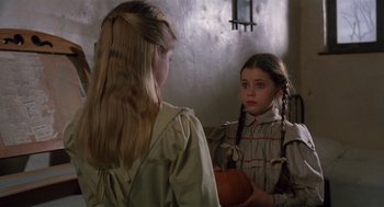 Movie still from “Return to Oz” (1985), directed by Walter Murch – A young girl looking in the mirror while holding a pumpkin; Medium shot, Over the shoulder angle