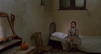 Movie still from “Return to Oz” (1985), directed by Walter Murch – A little girl sitting on a chair in a room; Wide shot, High angle