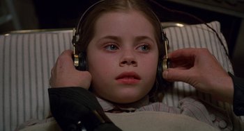 Movie still from “Return to Oz” (1985), directed by Walter Murch – A young girl wearing headphones while sitting in a chair; Close Up shot, High angle