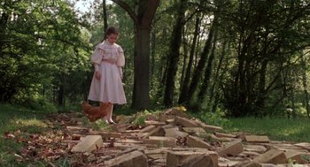 Movie still from “Return to Oz” (1985), directed by Walter Murch – A young girl in a pink dress standing in the middle of a pile of rubble; Wide shot, Low angle