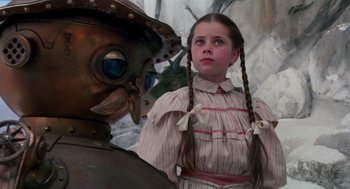 Movie still from “Return to Oz” (1985), directed by Walter Murch – A young girl standing in front of an iron man; Close Up shot, Low angle