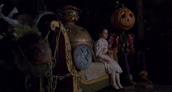Movie still from “Return to Oz” (1985), directed by Walter Murch – A little girl sitting on top of a bench next to pumpkins; Wide shot, High angle